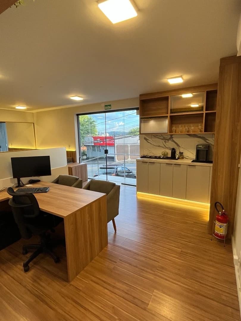 Escritório Moderno e Funcional: Ambiente contemporâneo com móveis em madeira clara, iluminação suave e detalhes em branco, proporcionando conforto e eficiência para o trabalho.